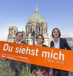 Personen mit "Du siehst mich"-Banner vor Berliner Dom.